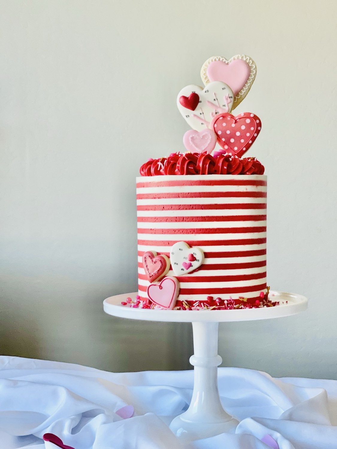 Heart cookies decorating a striped cake
